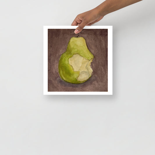 Product mockup image includes a hand holding a print of my painting of a green pear with a bite taken out of it against a plum colored background.