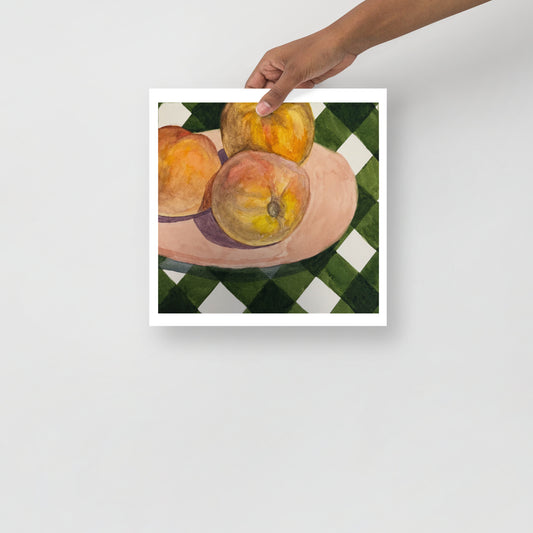 Still life painting of peaches on a checkered tablecloth