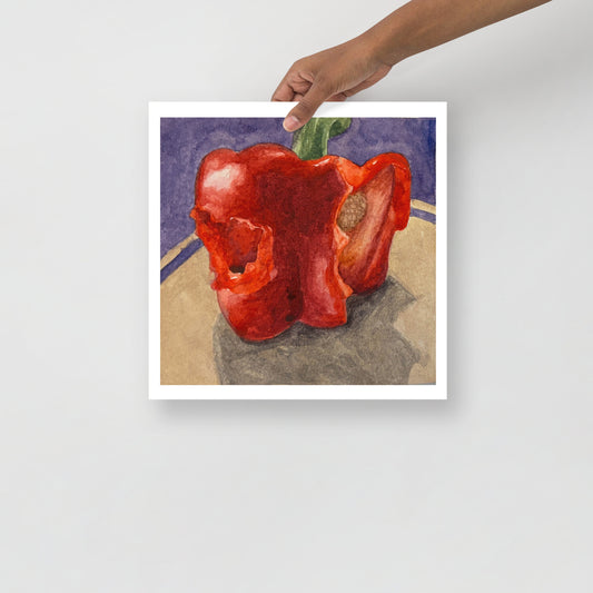 Product mockup of a watercolor painting of a red bell pepper with bites taken out of it on a textured surface with a dark background