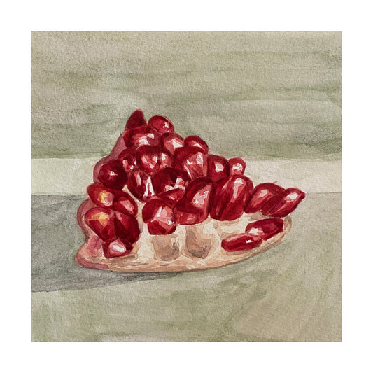 Red pomegranate chunk on a greyish green background