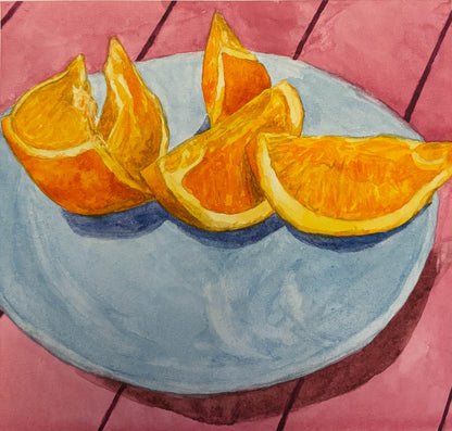 Sliced oranges on a blue plate with a pink tiled background