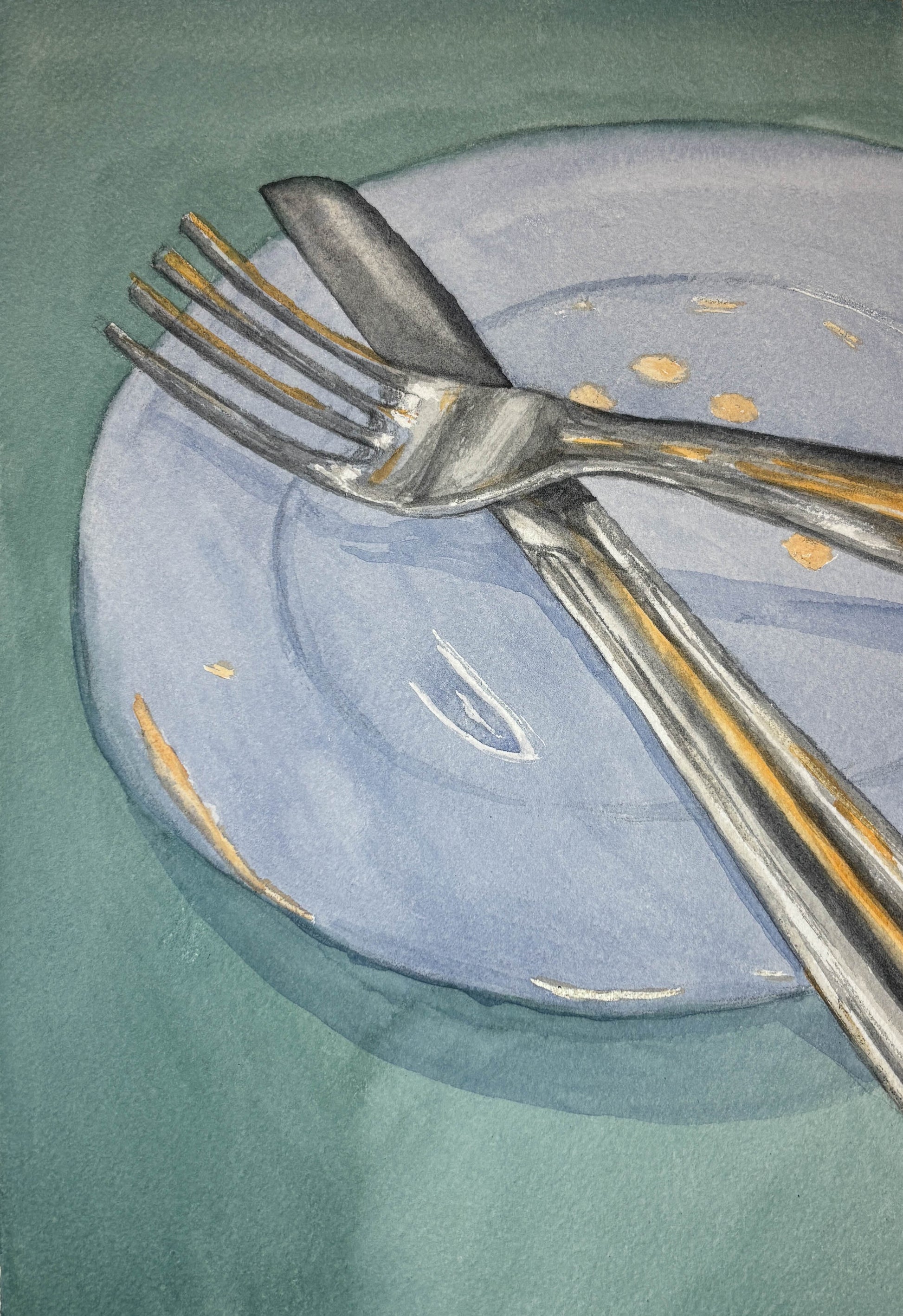 Silver fork and knife on a light blue plate with gold dots against a green background
