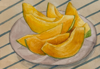 Sliced yellow fruit on a plate with a striped background