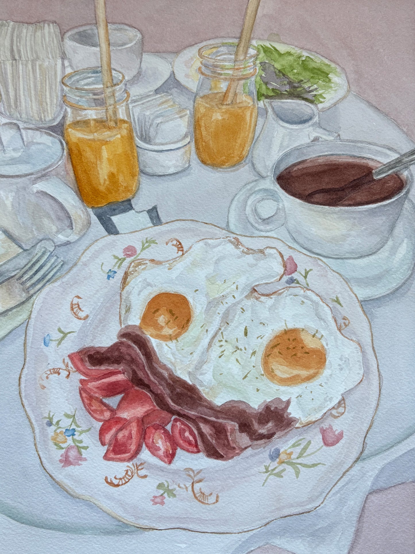 Watercolor painting of a breakfast table scene featuring a plate with two fried eggs, bacon, and sausage, alongside mason jars of orange juice, a cup of coffee, and other dining items.