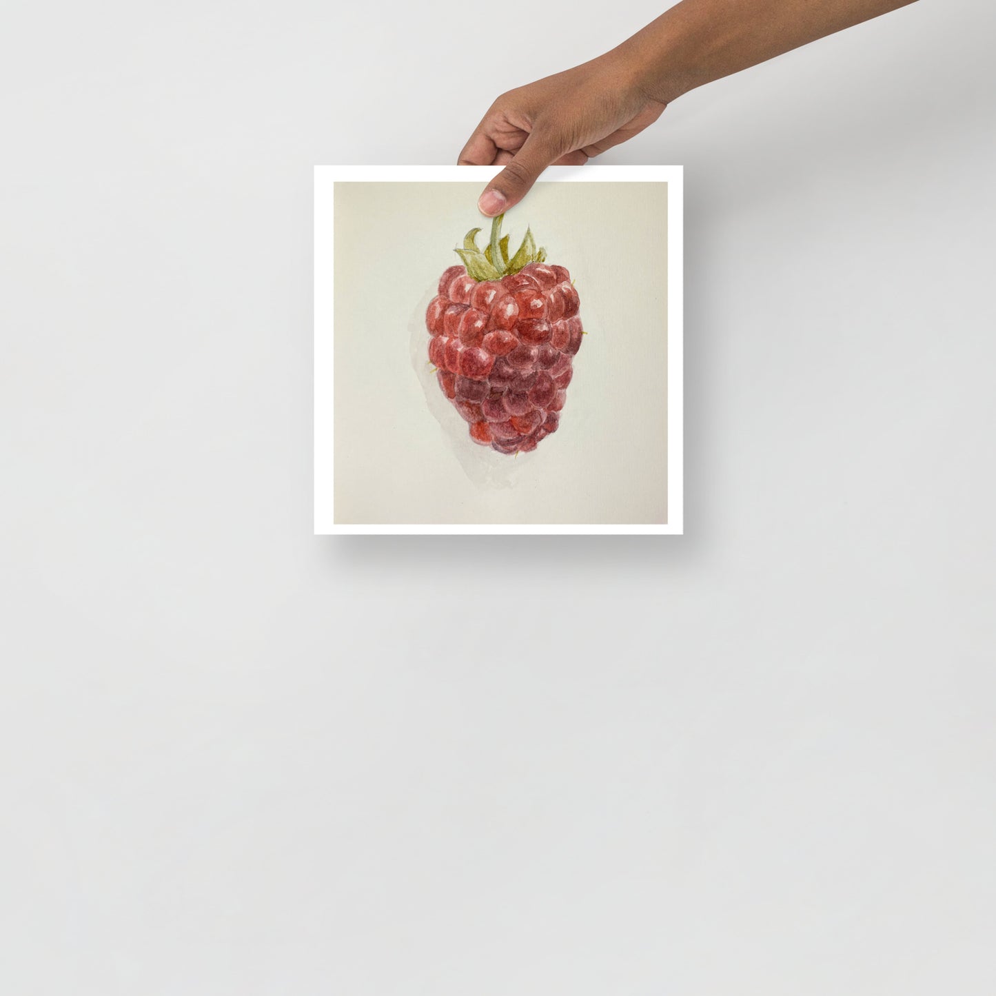 Product mockup of Watercolor painting of a red raspberry with a green stem against a white background.