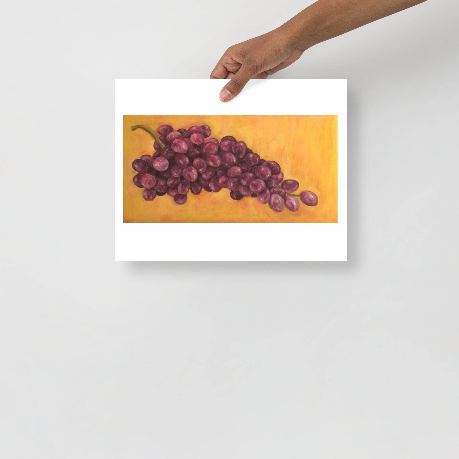 Product mockup of an oil painting print that depicts purple grapes against a yellow background
