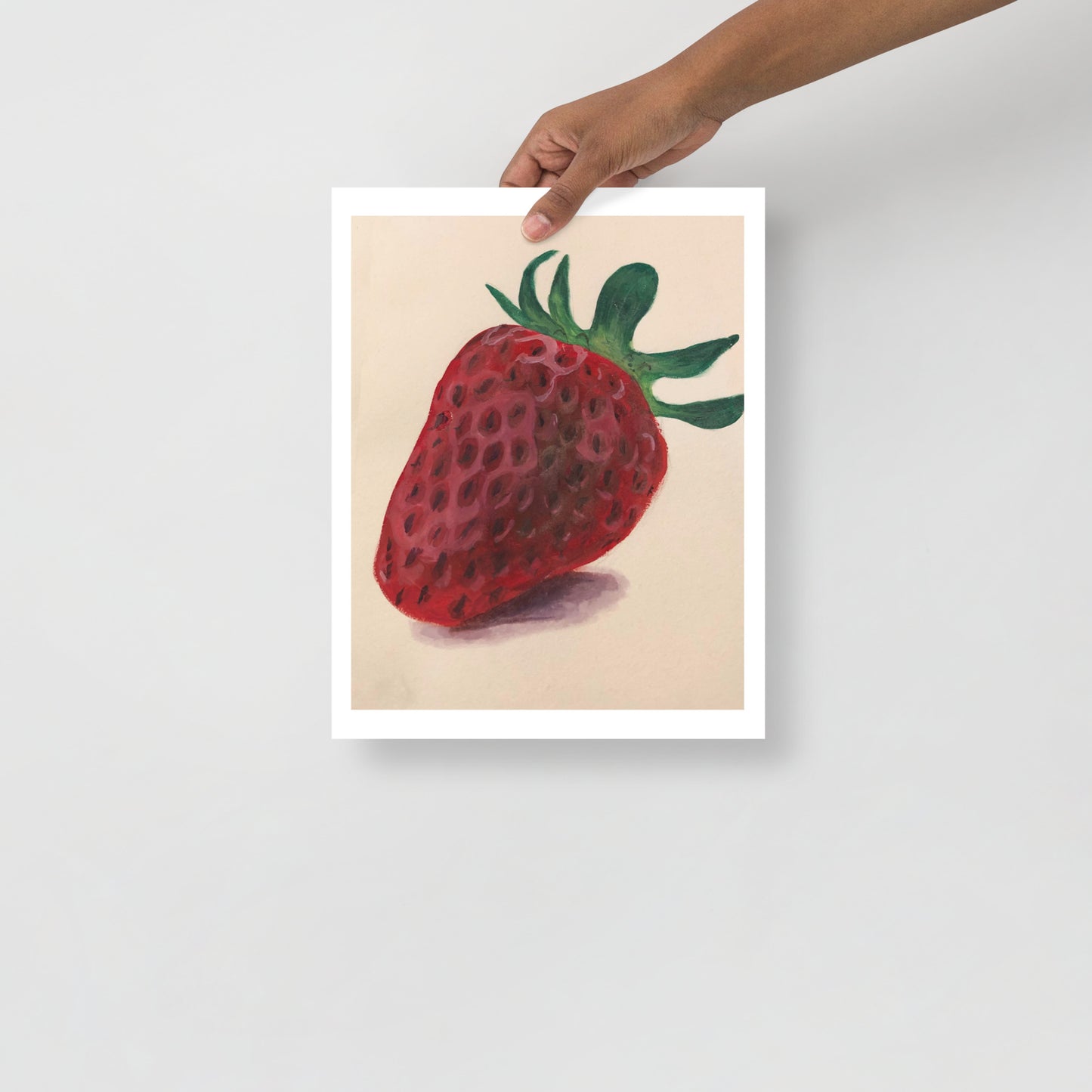 Product mockup of a gouache painting print of a red strawberry with green leaves on a beige background 