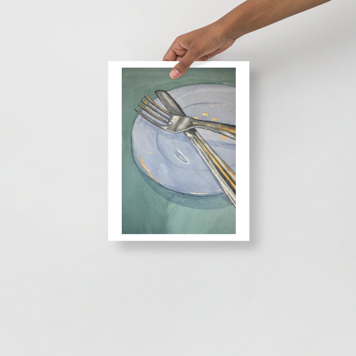 Product mockup of Silver fork and knife on a light blue plate with gold dots against a green background
