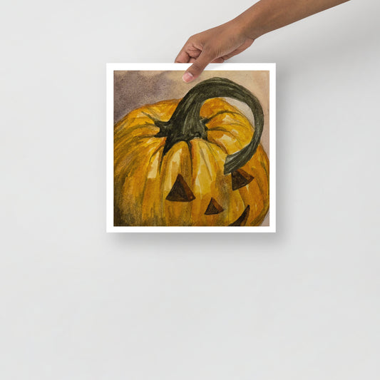 Product mockup of a watercolor painting print that depicts a pumpkin with a face carved into it on a textured beige background.