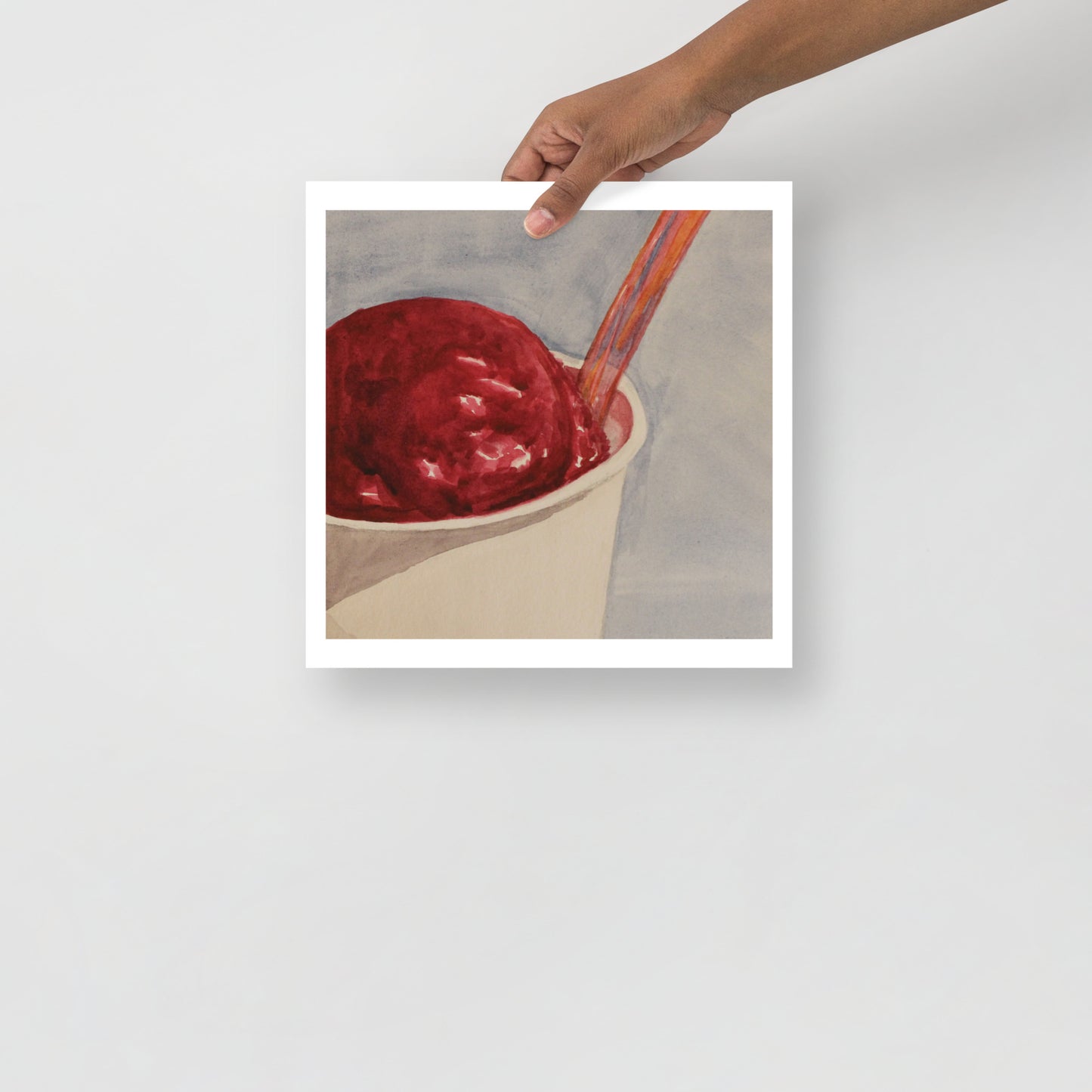 Product mockup of Raspberry gelato in a cup with a spoon on a light gray background