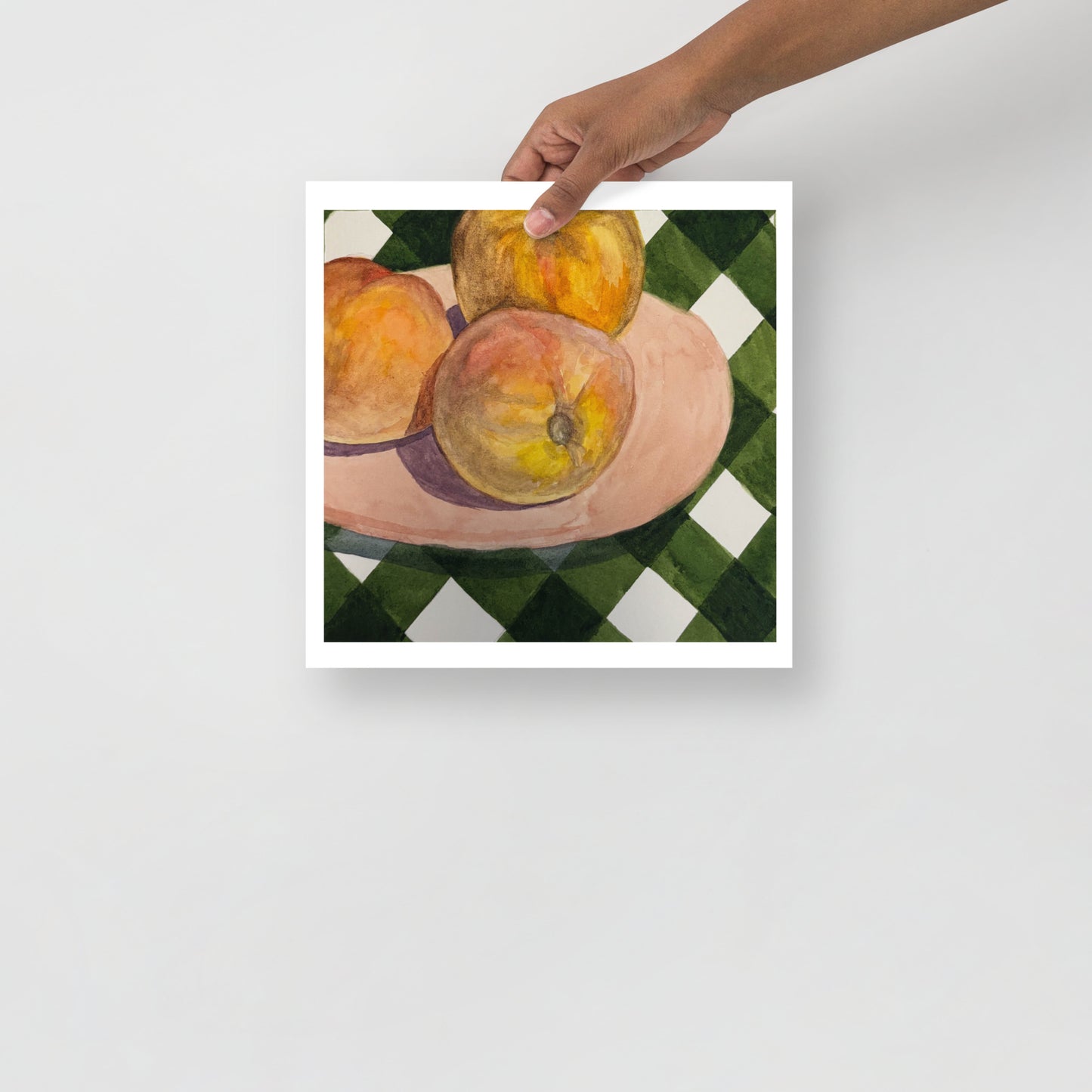 Still life painting of peaches on a checkered tablecloth