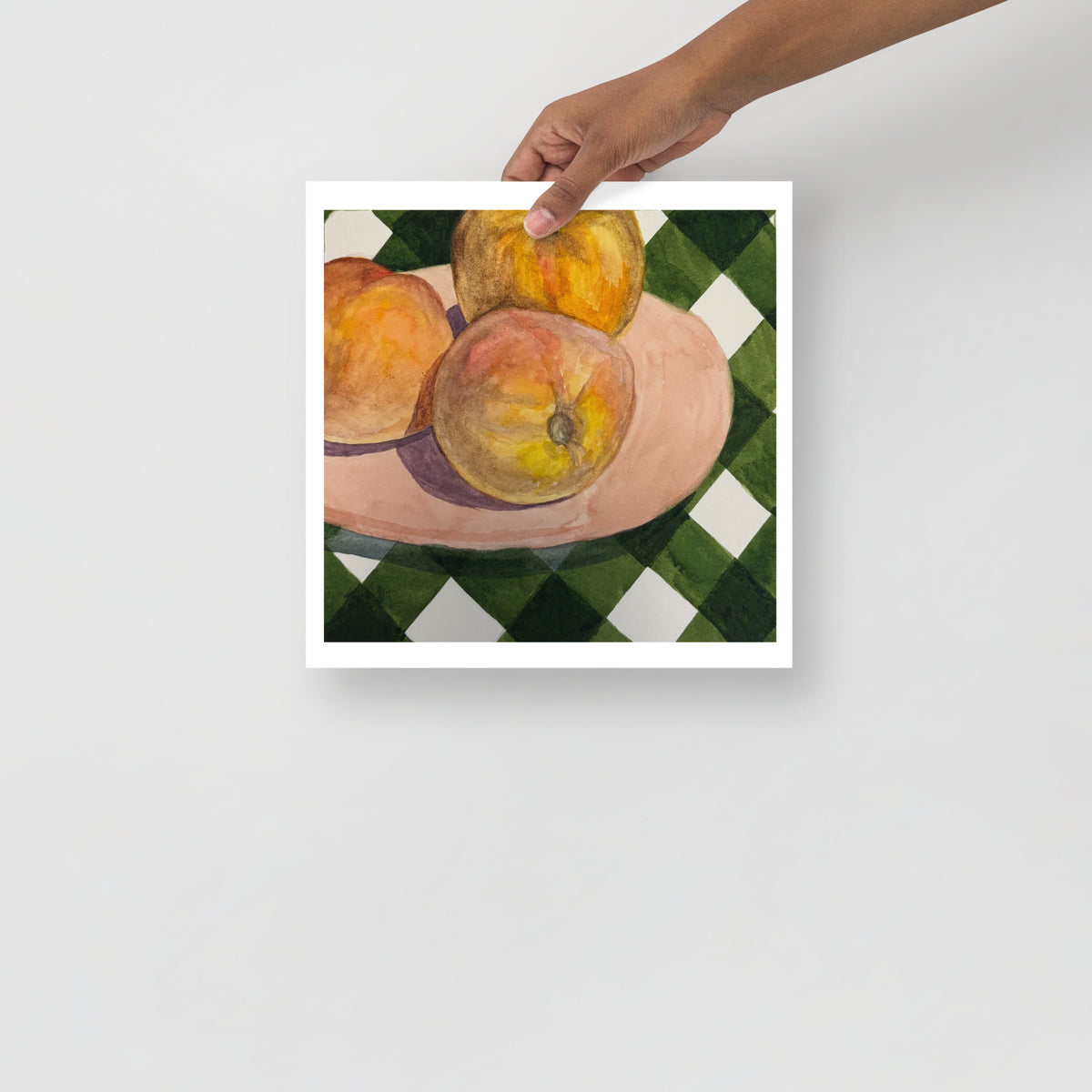 Still life painting of peaches on a checkered tablecloth