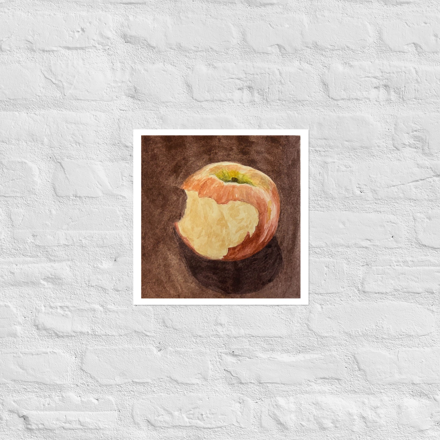 Product mockup of a watercolor painting print that depicts a red apple with a bite against a brown background 