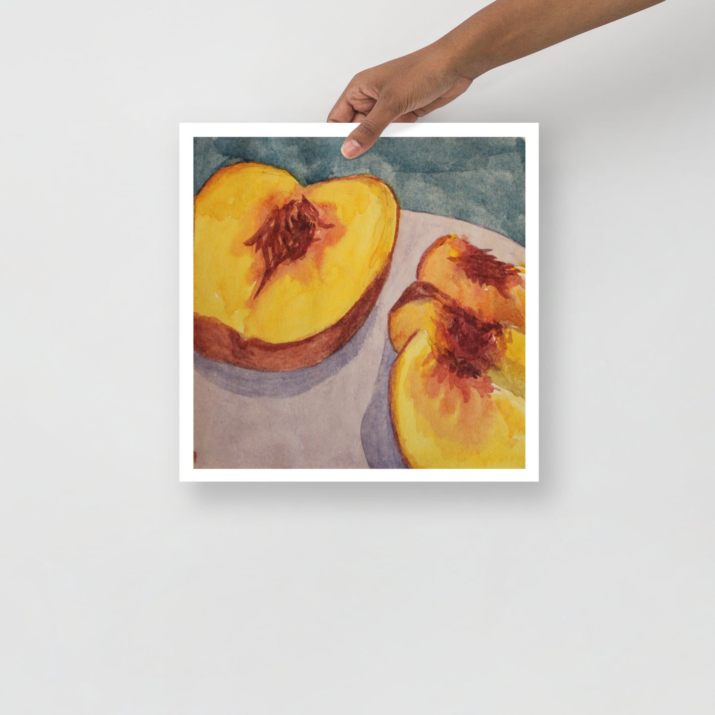 Product mockup of a watercolor print of a peach cut in half on a purple plate with a blue background