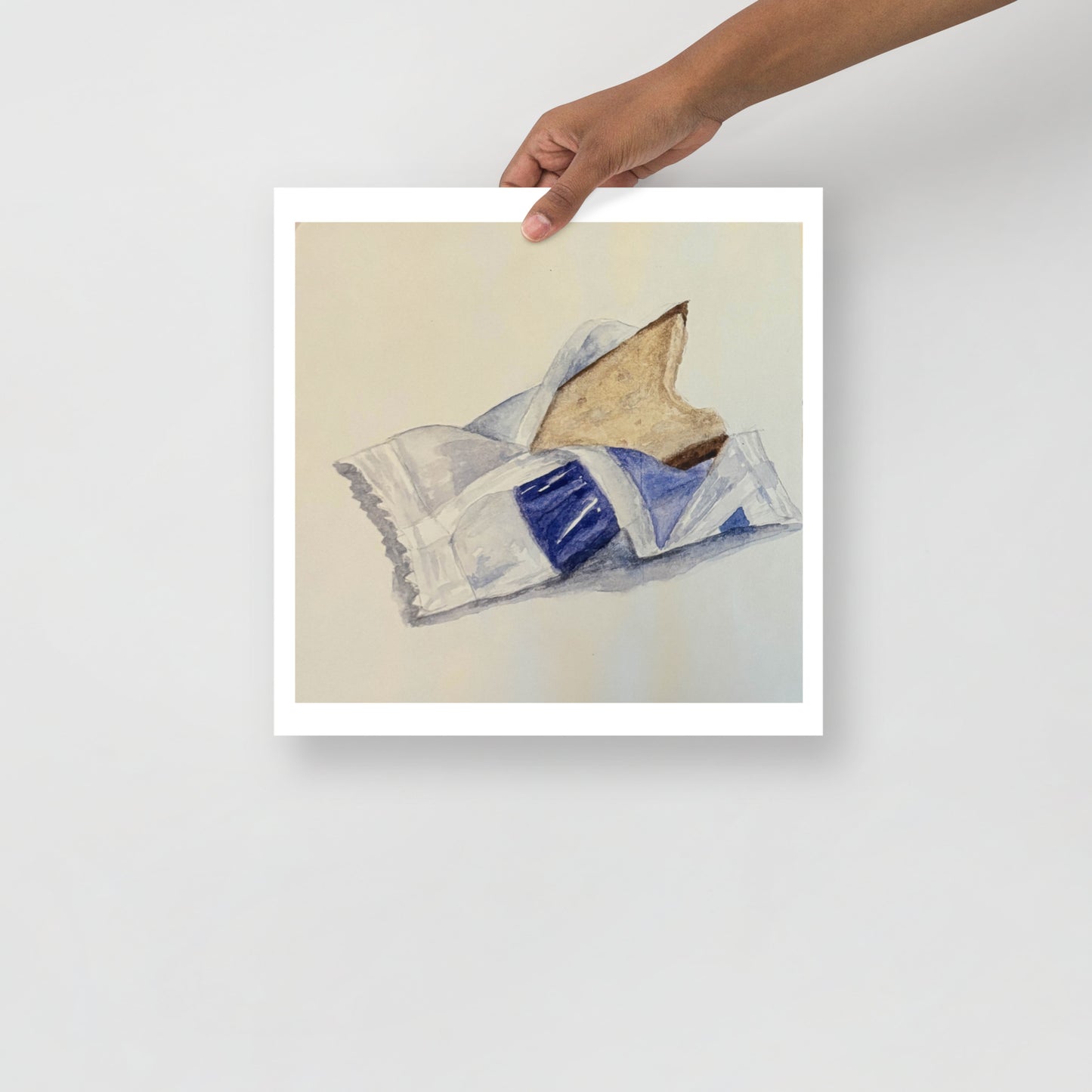 Product mockup of a watercolor print that depicts an artistic depiction of a candy half opened on a white background 