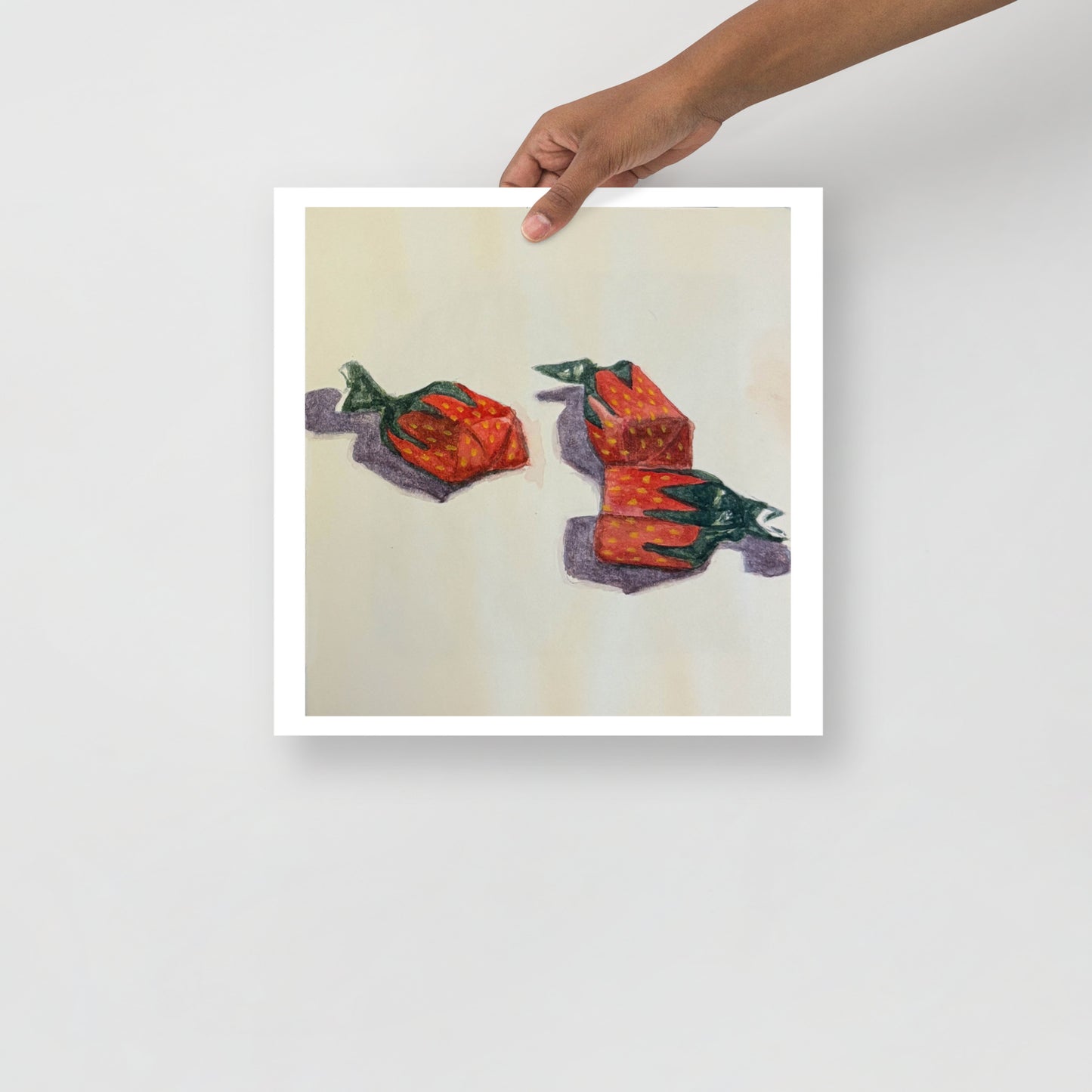 Product mockup of a watercolor print that depicts three red strawberry candies on a white background  