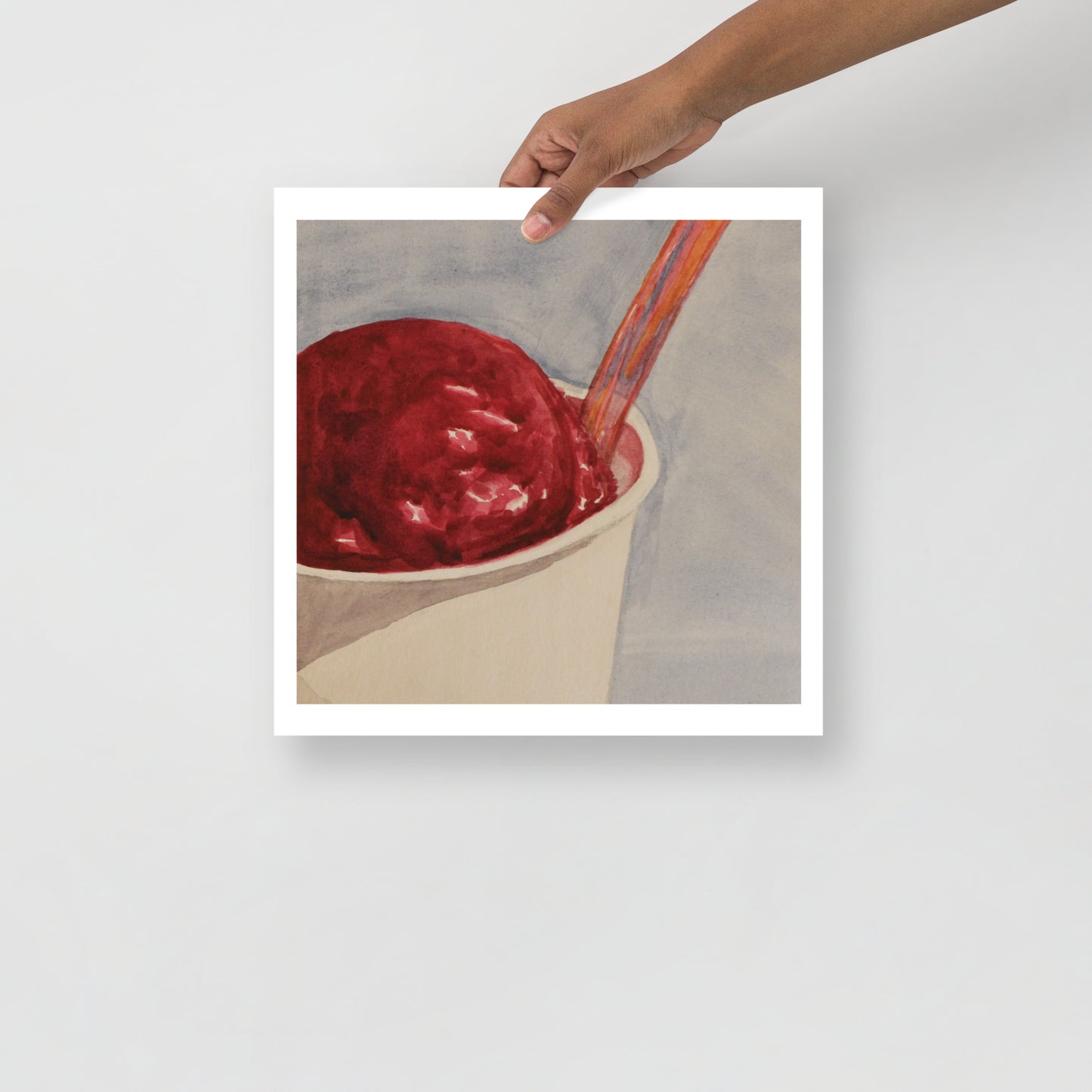 Product mockup of Raspberry gelato in a cup with a spoon on a light gray background
