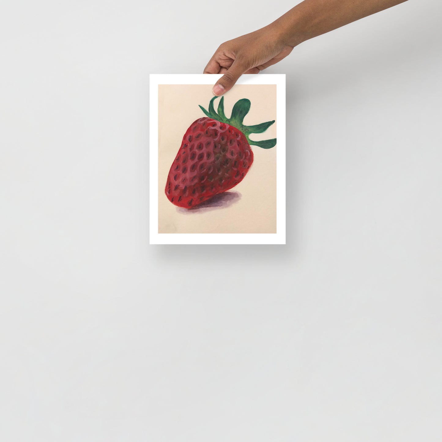Product mockup of a gouache painting print of a red strawberry with green leaves on a beige background 