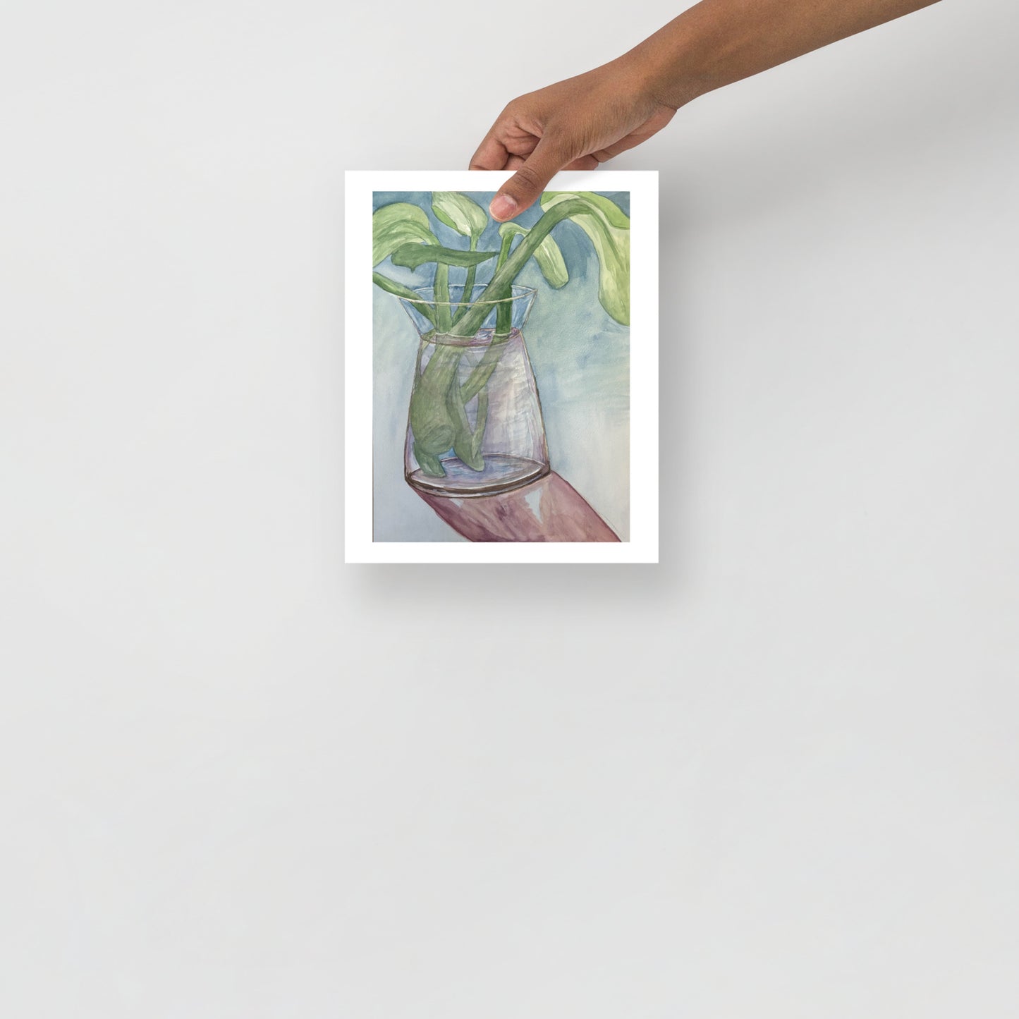 Art print of a glass vase with green leaves on a white background