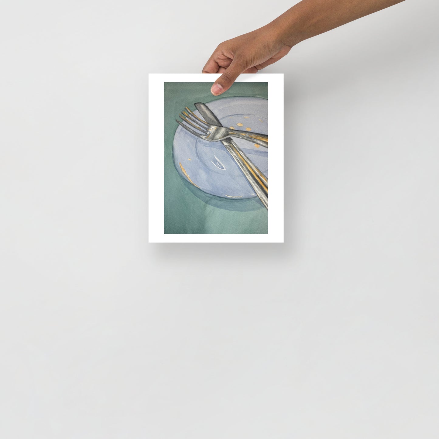 Product mockup of Silver fork and knife on a light blue plate with gold dots against a green background
